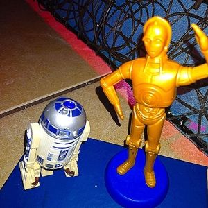 Mini collectible figurines of           R2D2 and C 3 P O  from StarWars movies.